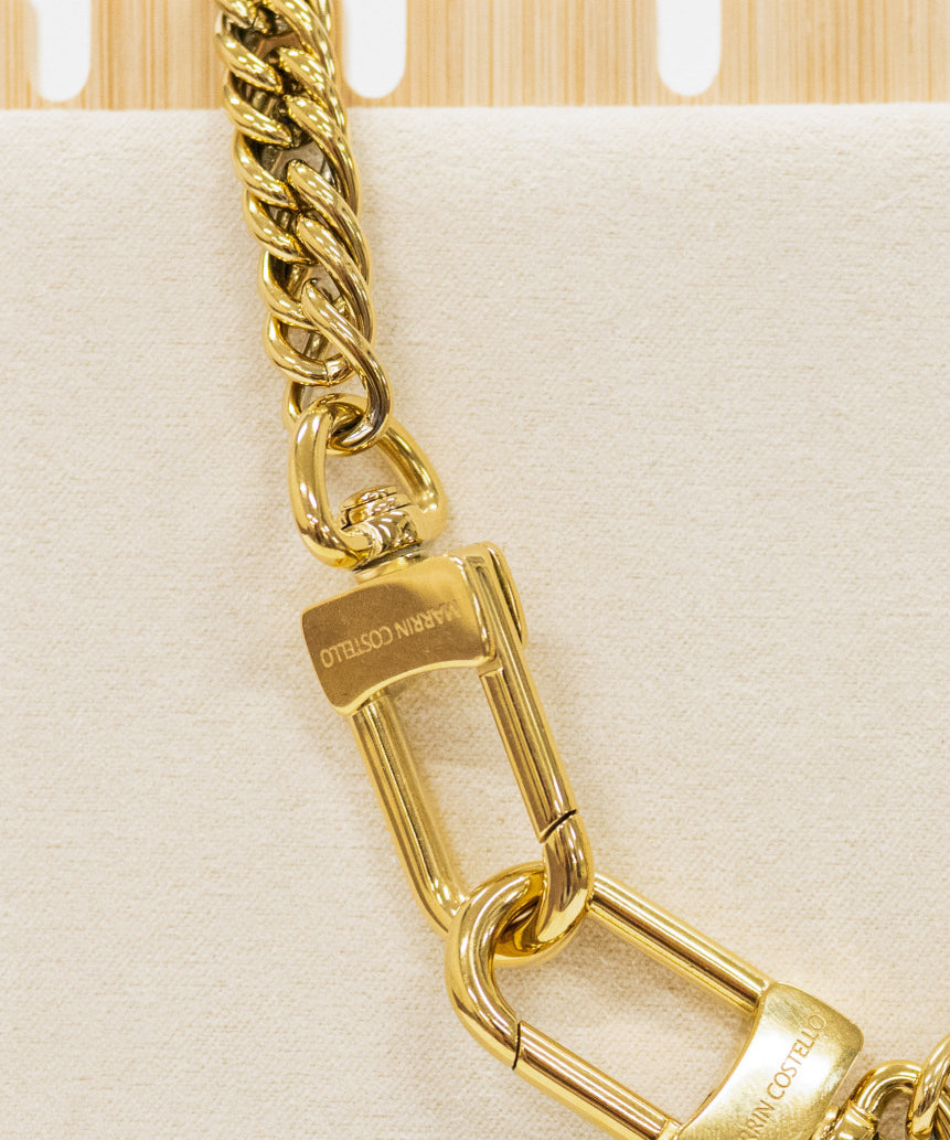Gold chain with padlock on a beige background