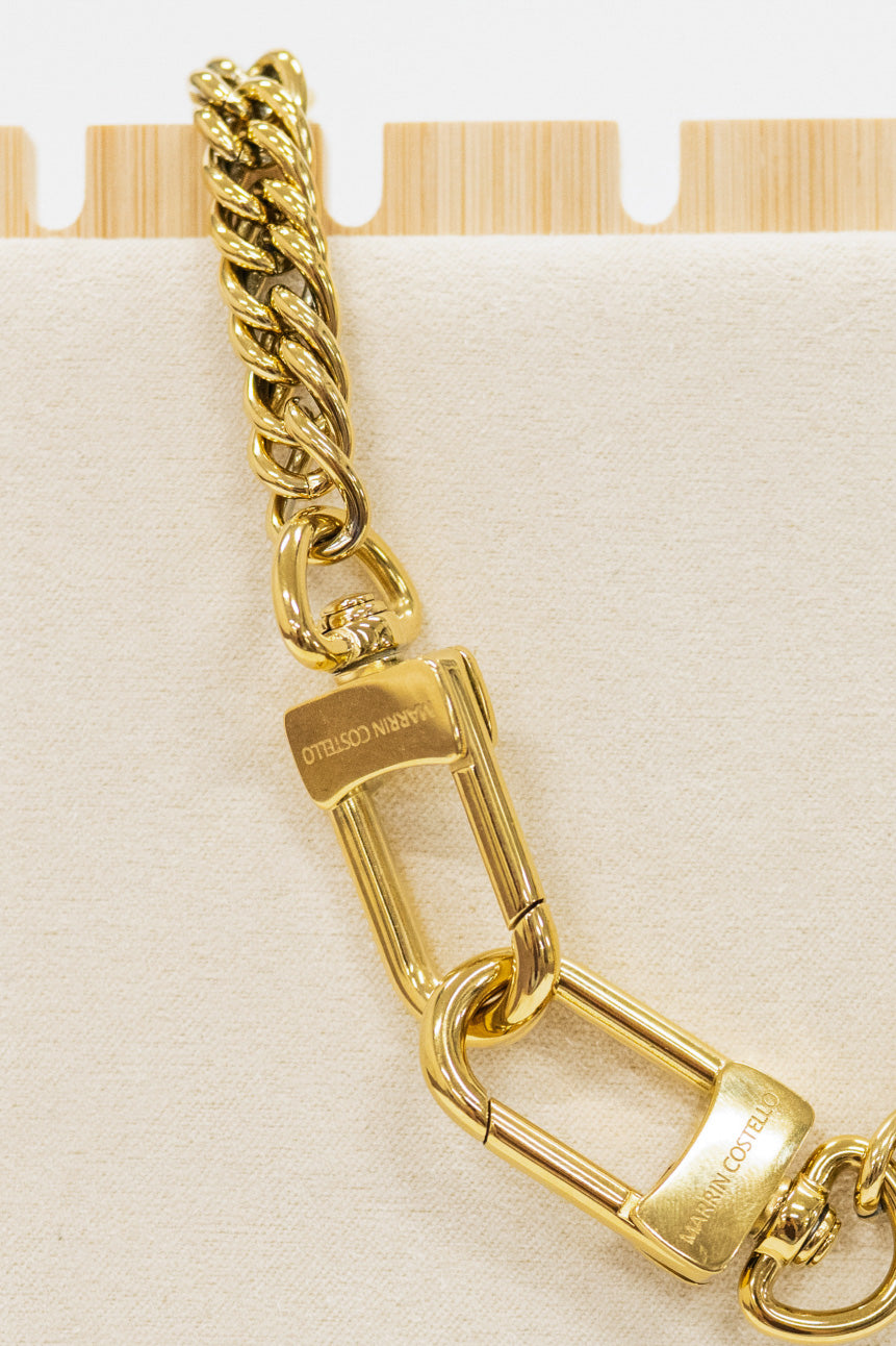 Gold chain with padlock on a beige background