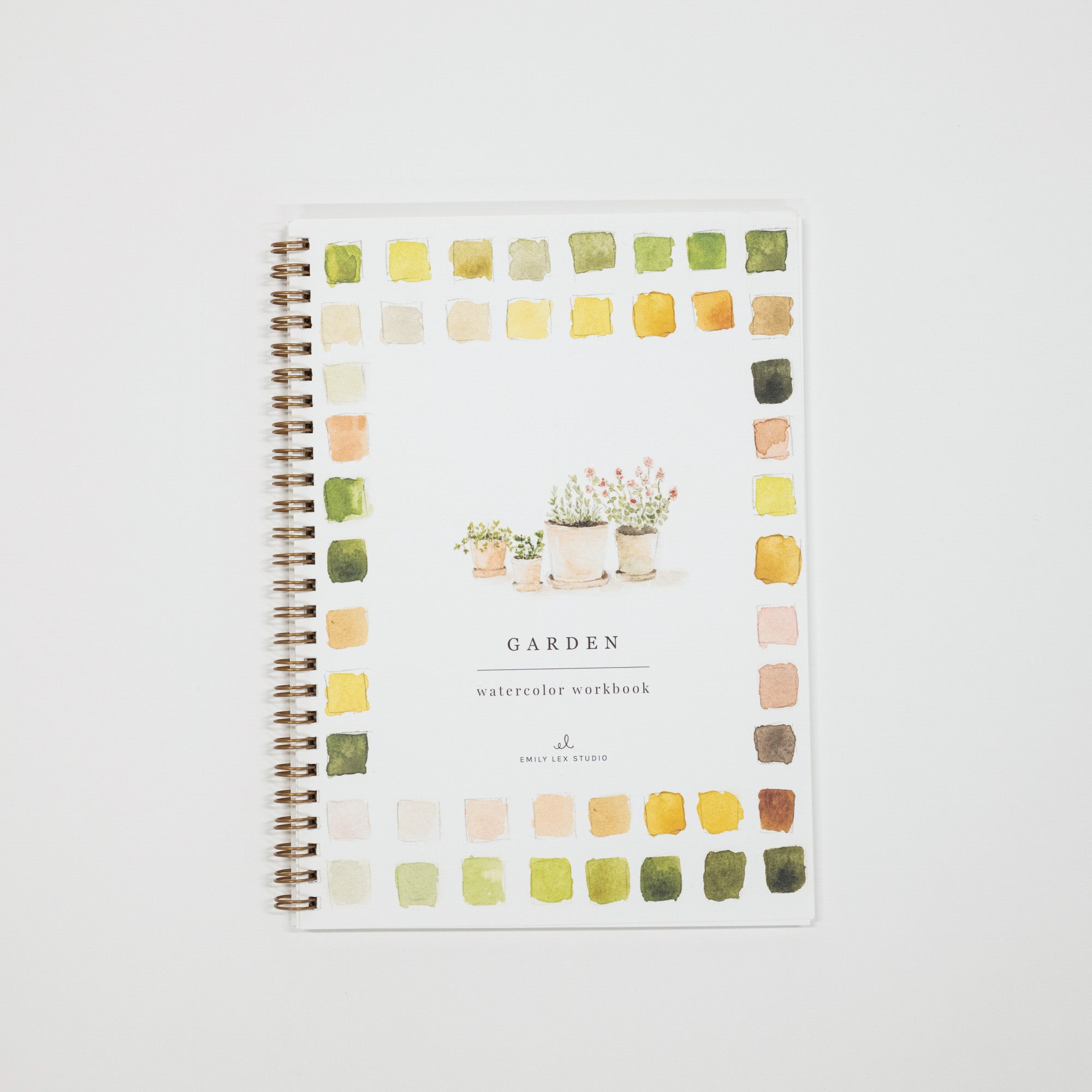 A spiral-bound watercolor workbook titled 'GARDEN' with a white cover, surrounded by a border of small watercolor paint swatches in green, yellow, orange, and pink. The cover also features a delicate illustration of potted plants in the center.