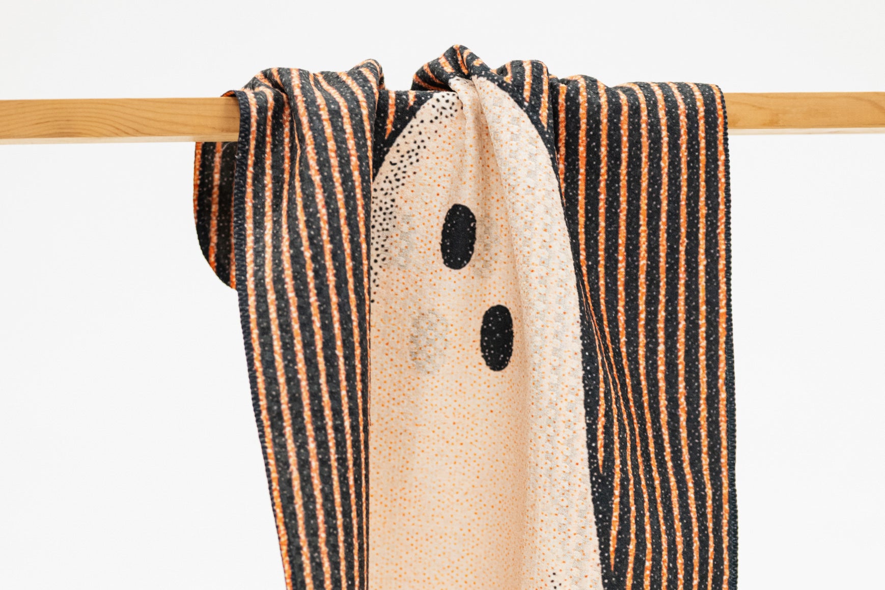 the top of a kitchen towel for fall with black and orange stripes and a ghost