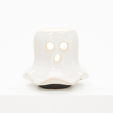 A small white ghost-shaped ceramic candle holder with cutout eyes and mouth, shown on a clean white background.