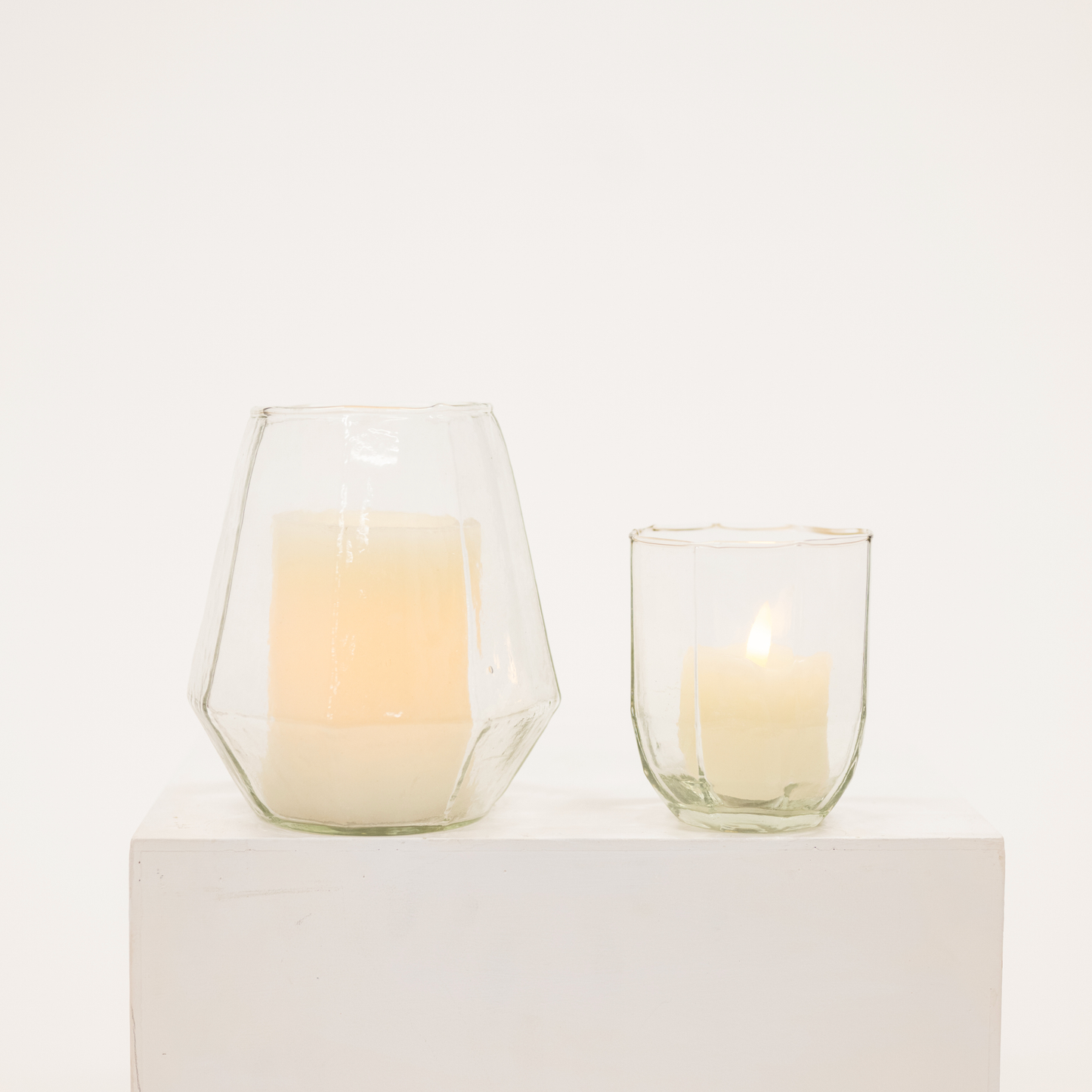 two glass candle hurricanes