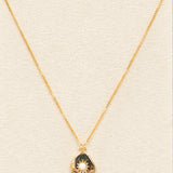 gold necklace featuring a pendant and small white opal. with a gold chain necklace