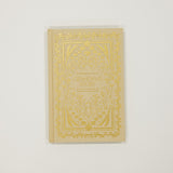 Decorative book with gold embossed design on a light gray background