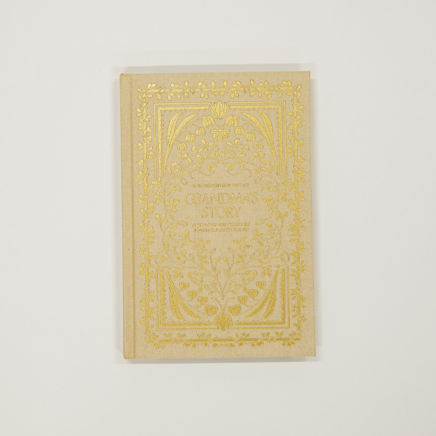 Decorative book with gold embossed design on a light gray background