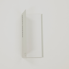 Grid-patterned sticky note with text on a white background