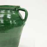 Green ceramic jar with a handle on a white background