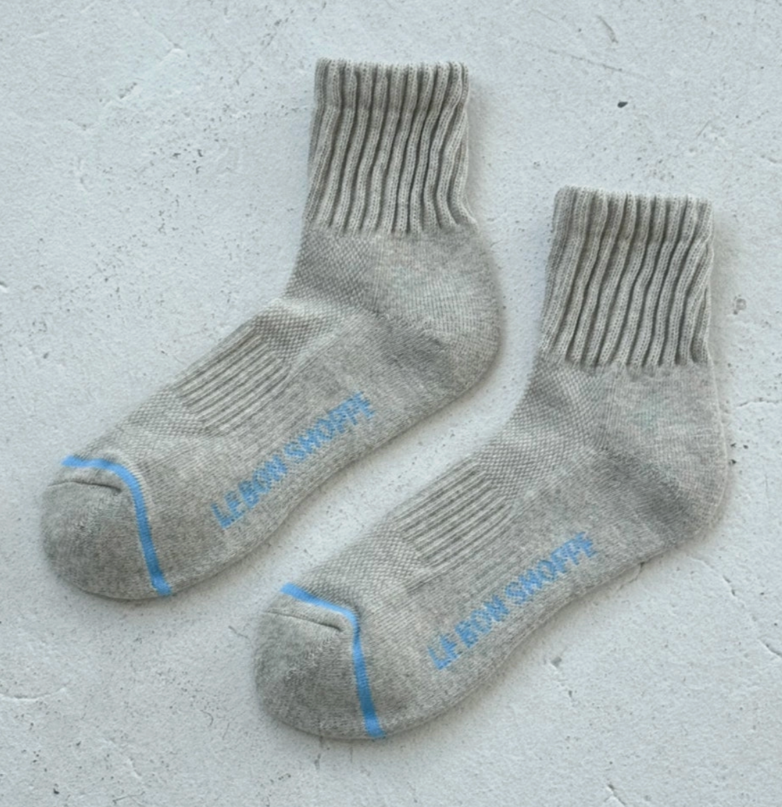 Pair of gray socks with blue accents on a light gray background