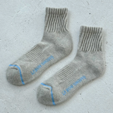 Pair of gray socks with blue accents on a light gray background