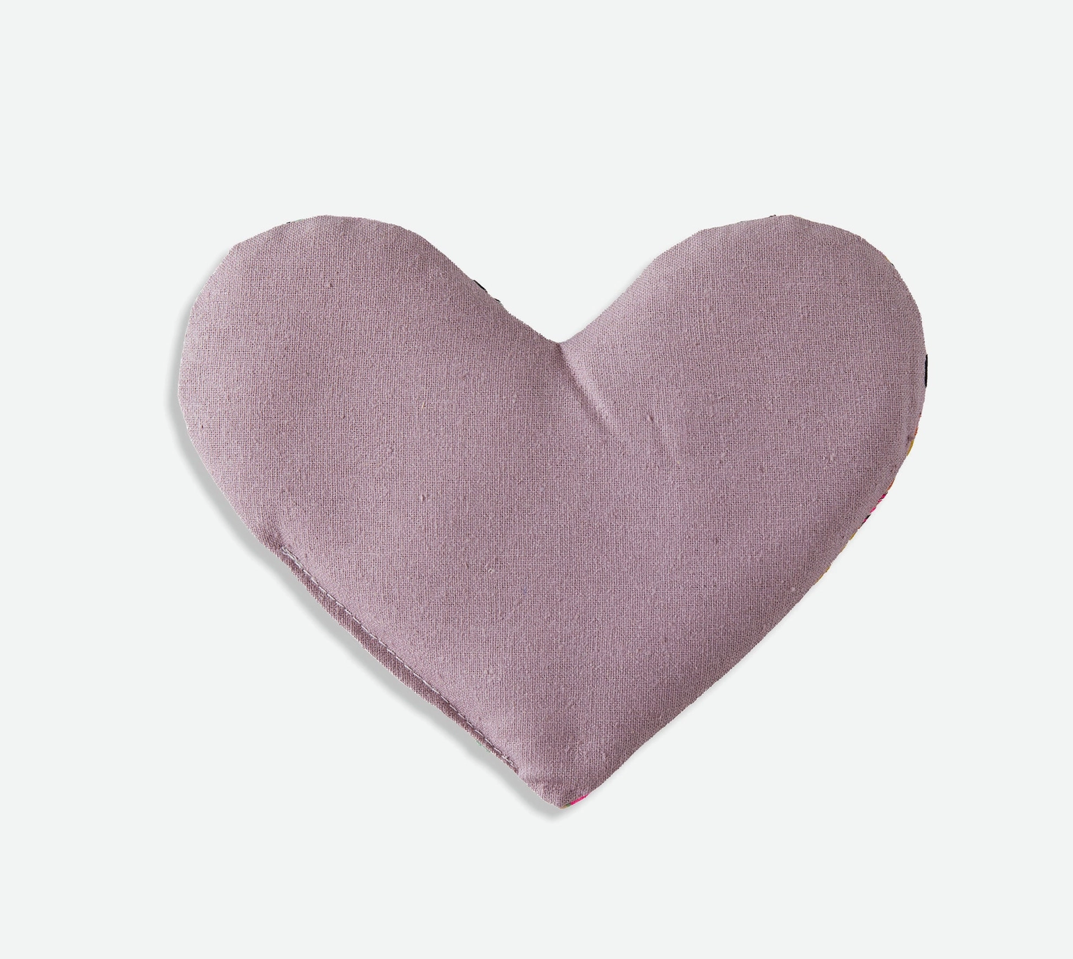 Heart-shaped eye pillow in a soft purple silk on a light gray background
