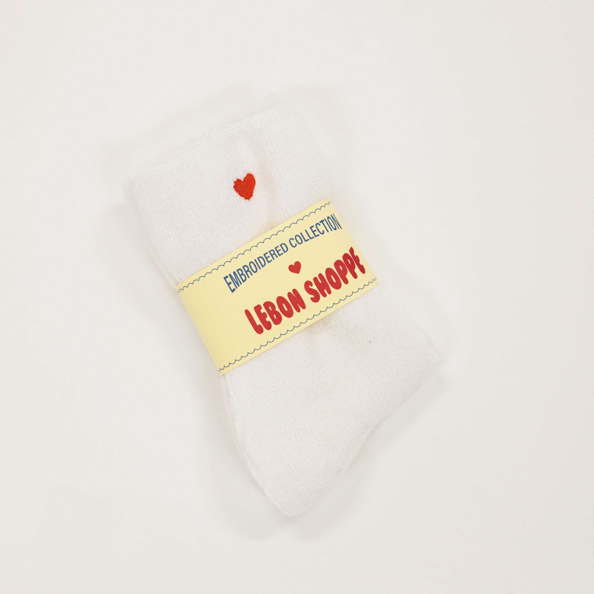 White sock with a yellow label reading 'Lebon Shoppe' on a white background