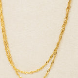 Gold chain necklace on a beige background