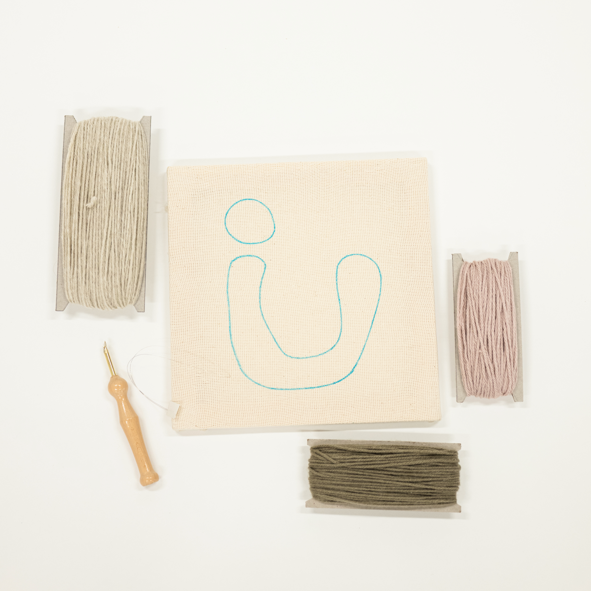 Embroidery kit with fabric, thread, and tools on a white background