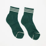 A pair of dark green crew socks with white stripes on the ribbed cuffs and white trim on the toes, displayed against a plain white background.