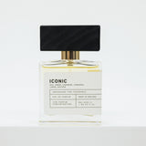 Perfume bottle with black cap and white label on a light gray background