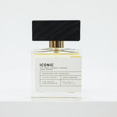 Perfume bottle with black cap and white label on a light gray background