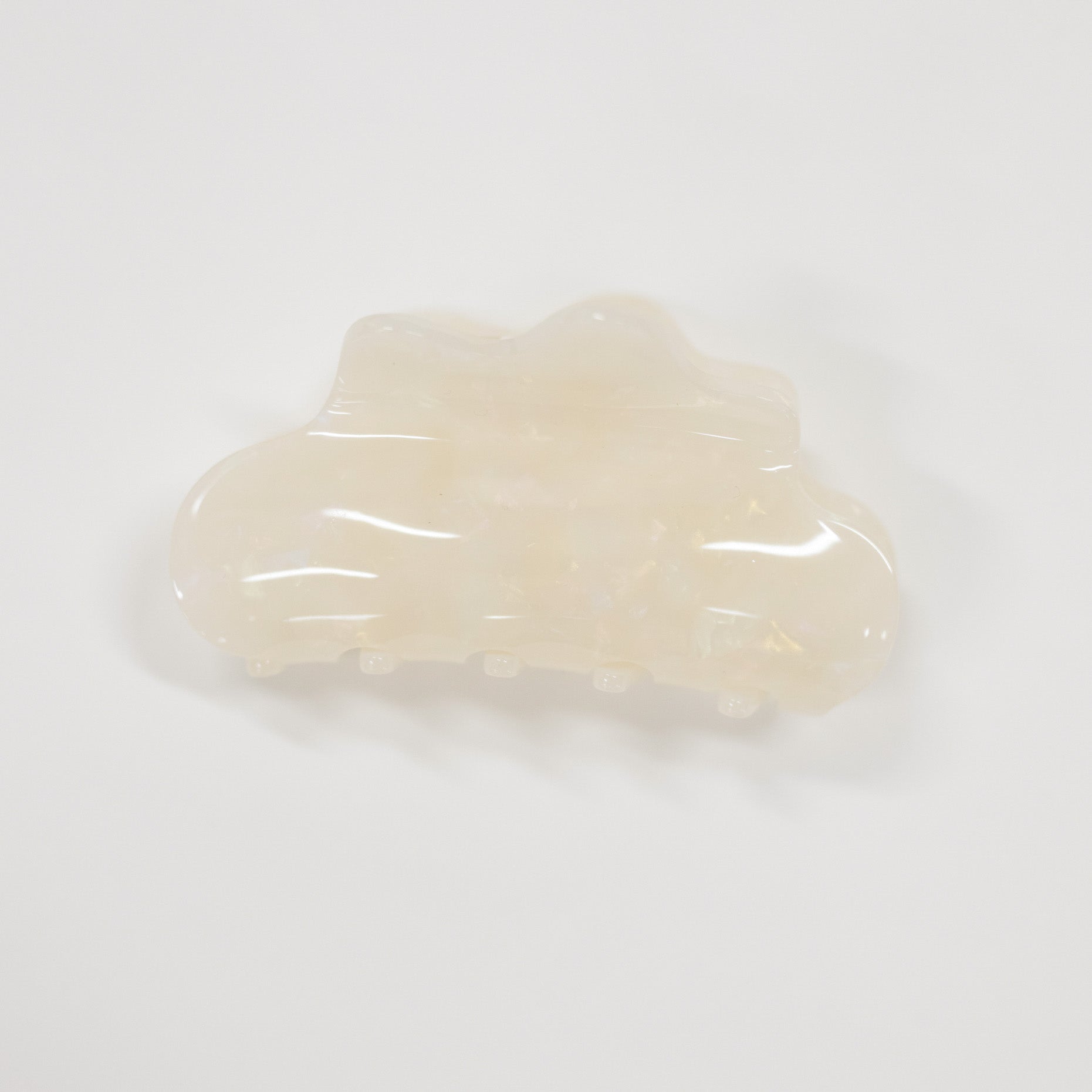 A translucent cream-colored hair claw clip with a glossy finish, photographed on a seamless white background.