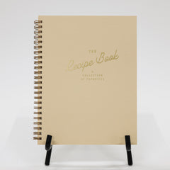 Beige recipe book with gold text on a white background