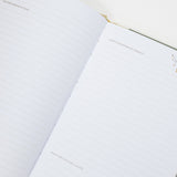 Open notebook with floral designs on a white surface