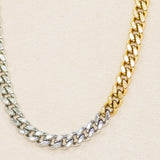 Two-tone gold and silver chain necklace on a beige background