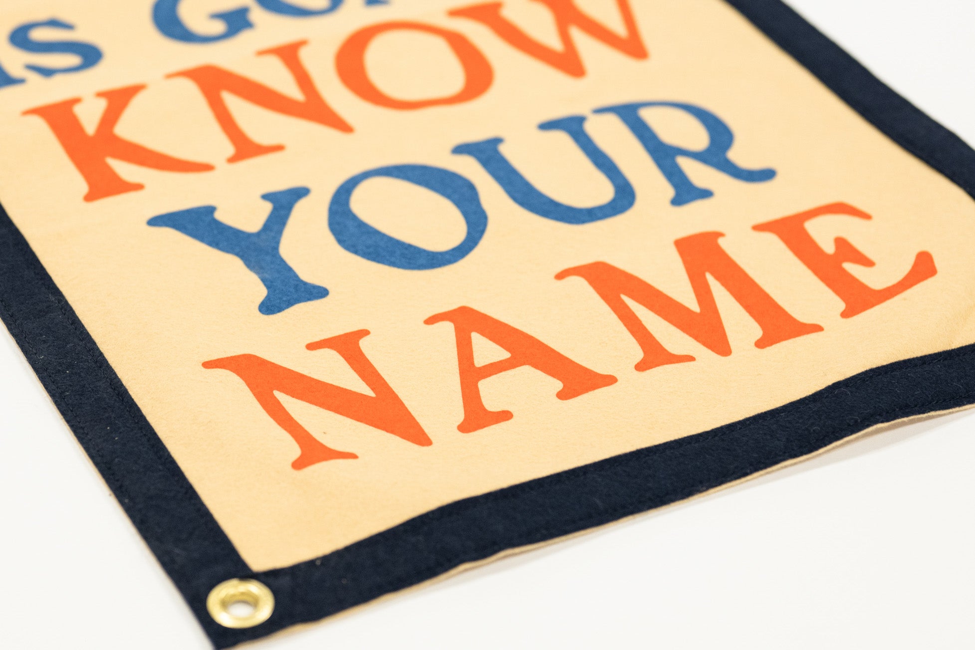 Colorful sign with text 'The world is going to know your name.' on a beige background.