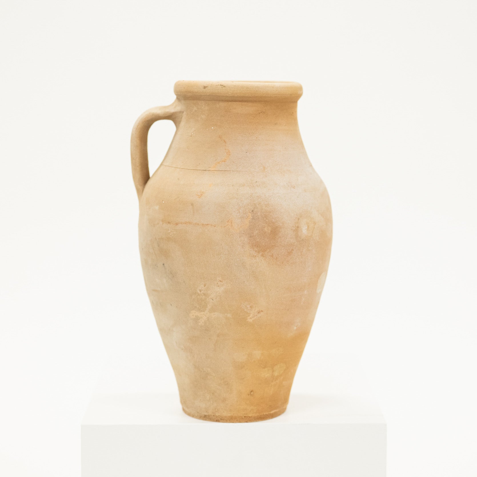 Beige ceramic pitcher on a white background