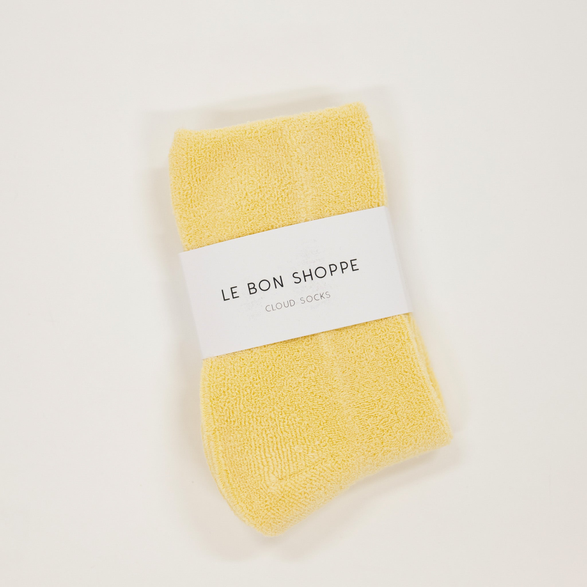 Yellow socks with a white label on a light gray background