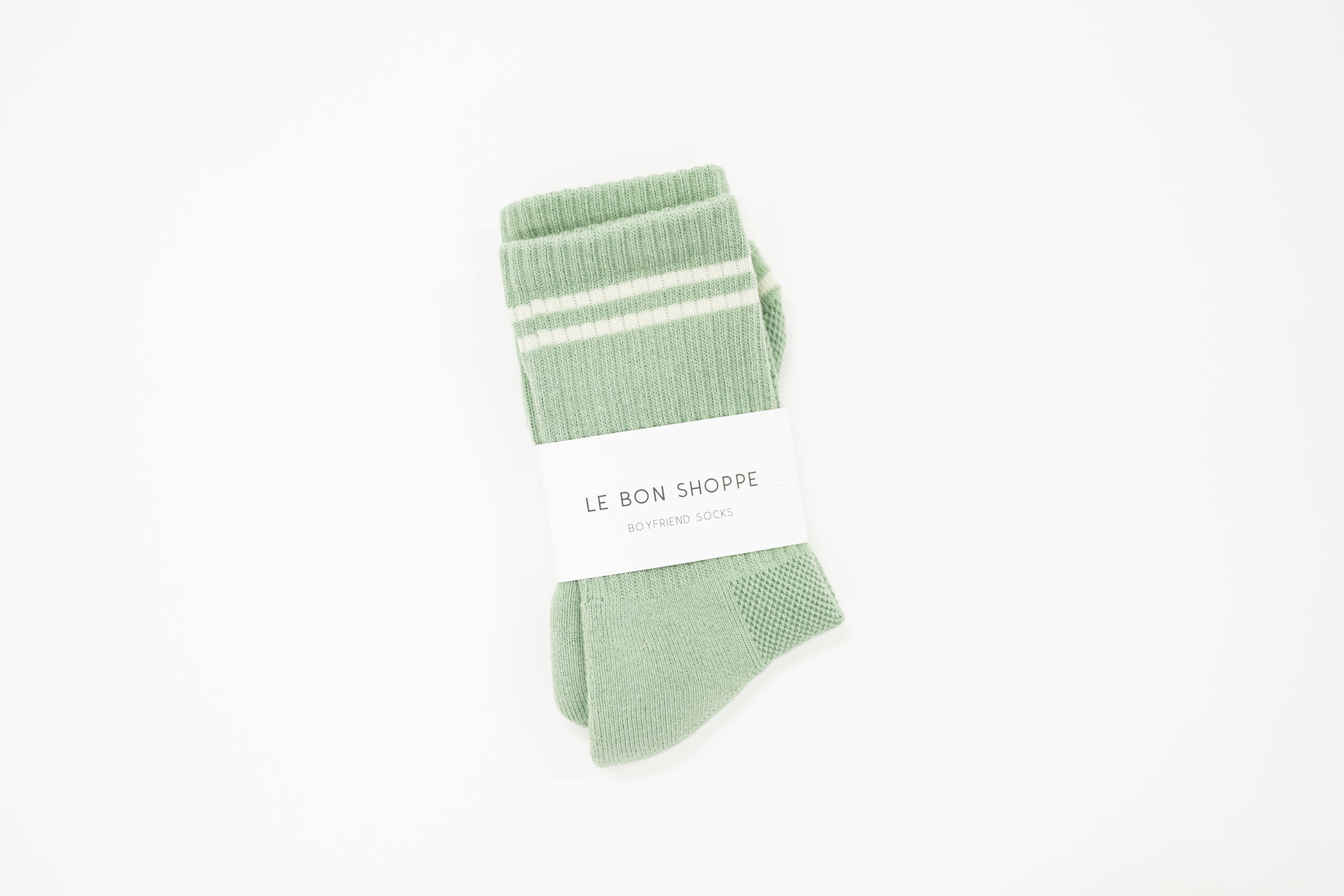 light green boyfriend style crew sock with white stripes and the white label saying the brand name le bon shoppe