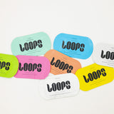 Colorful 'LOOPS' face masks on a light gray background