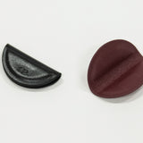 Two magnetic bookmarks, one black and one brown, on a white background