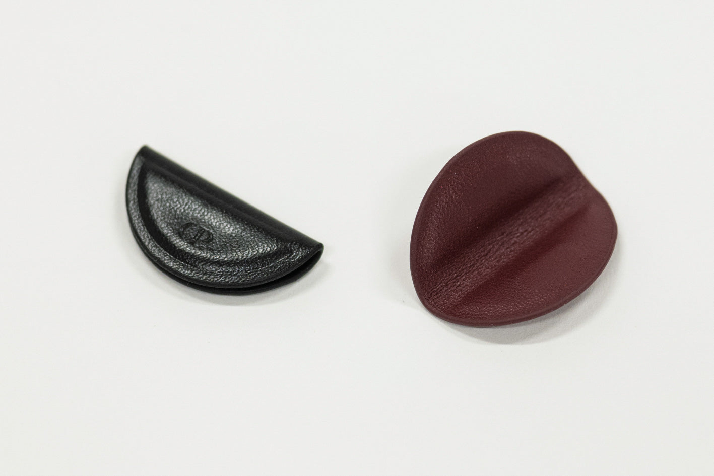 Two magnetic bookmarks, one black and one brown, on a white background