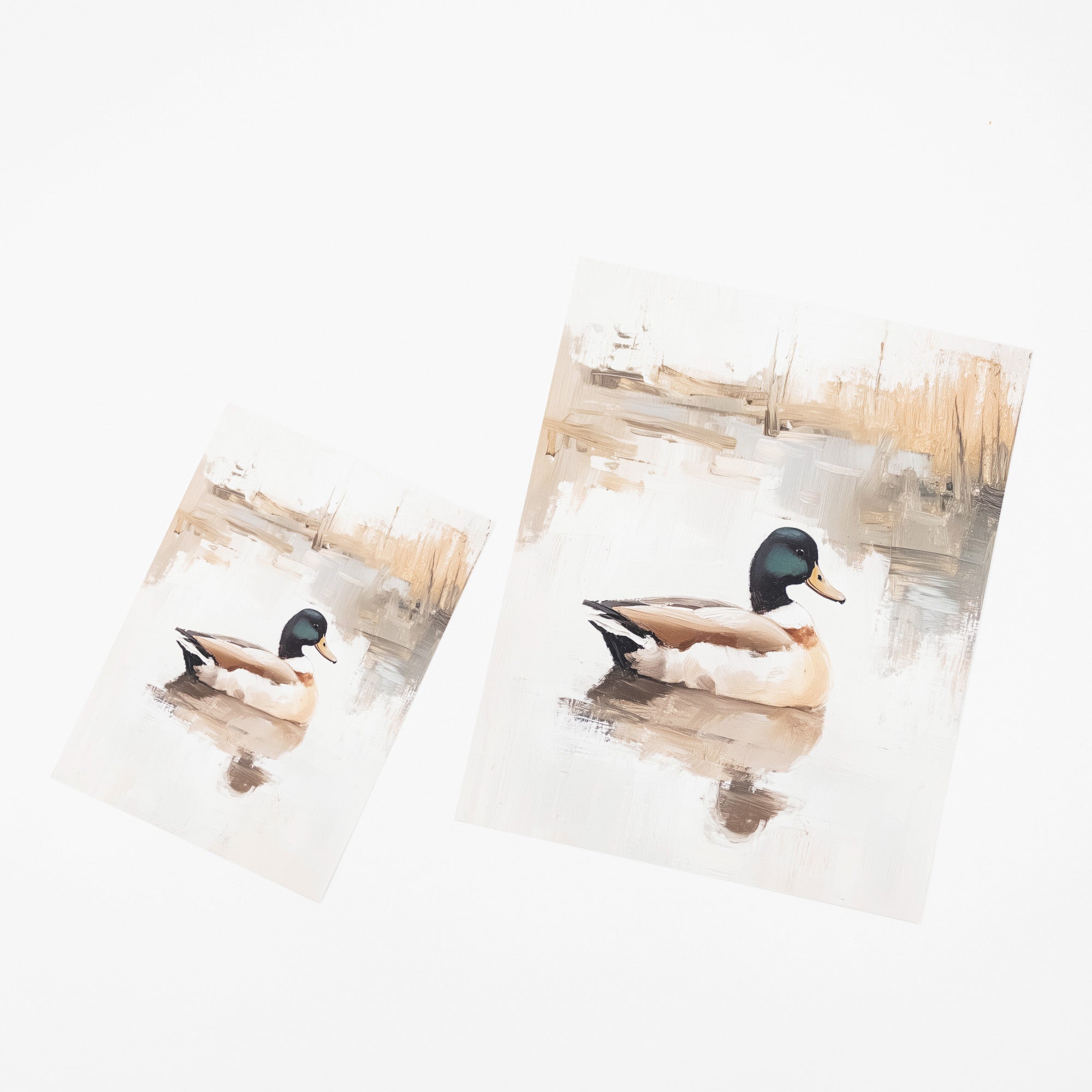 Two watercolor-style art prints depicting mallards on a reflective pond, shown on a clean white background.