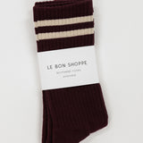 Pair of maroon brown and white striped socks with 'Le Bon Shoppe' label on a light gray background