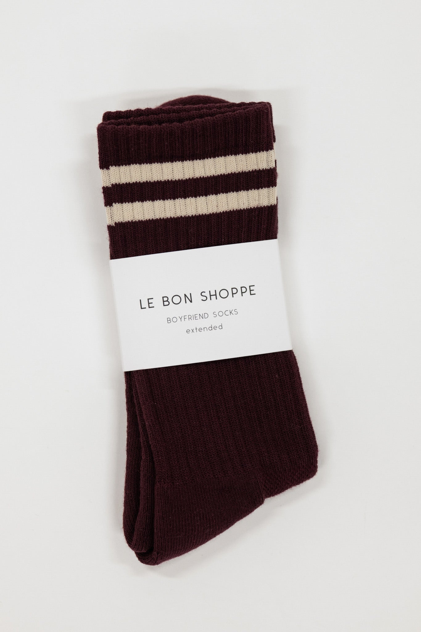 Pair of maroon brown and white striped socks with 'Le Bon Shoppe' label on a light gray background