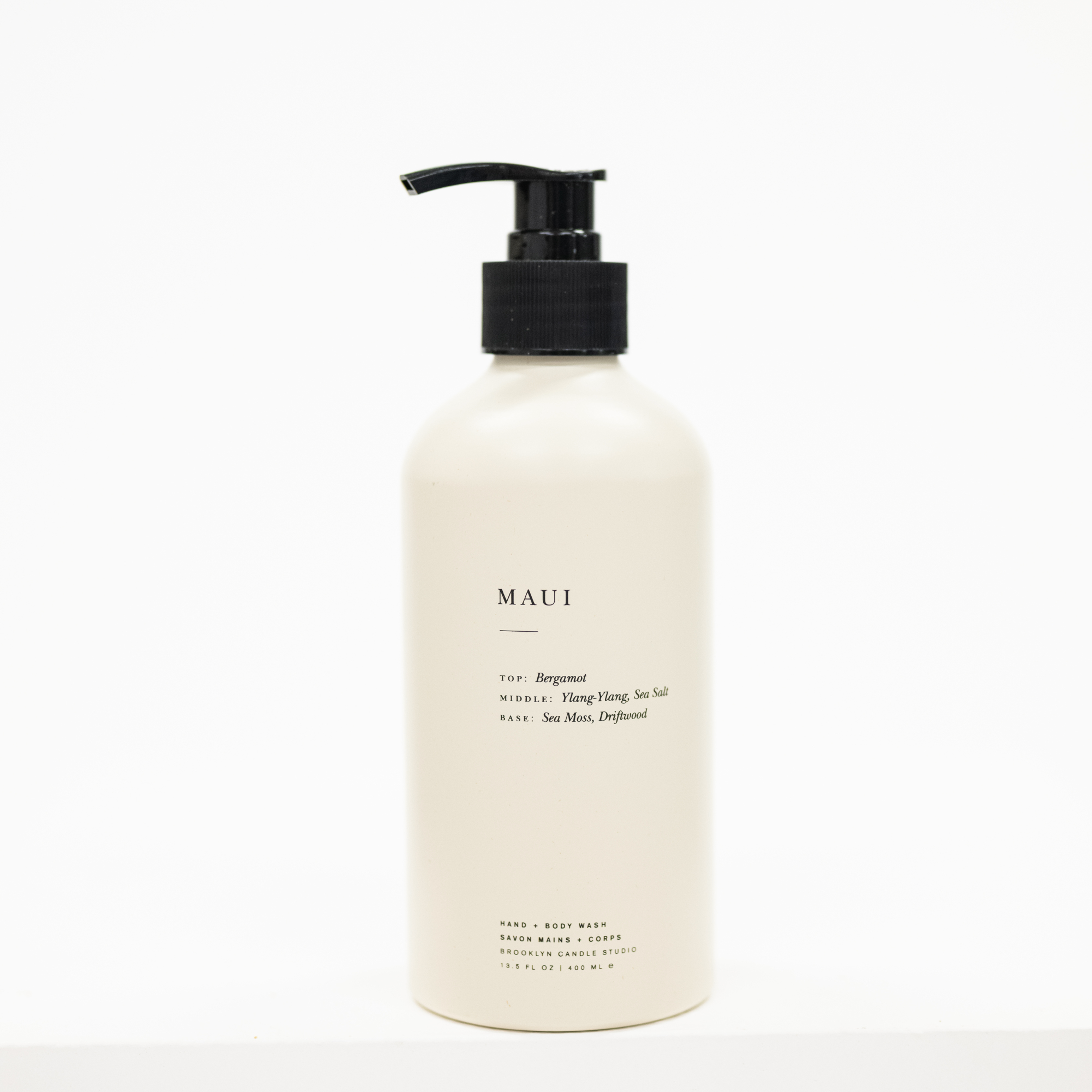 A matte off-white pump bottle of Maui body wash with a black dispenser, set against a clean white background.