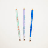 Three colored pencils in green, purple, and blue on a white background