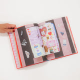 Open book with colorful pages held by a hand on a white background