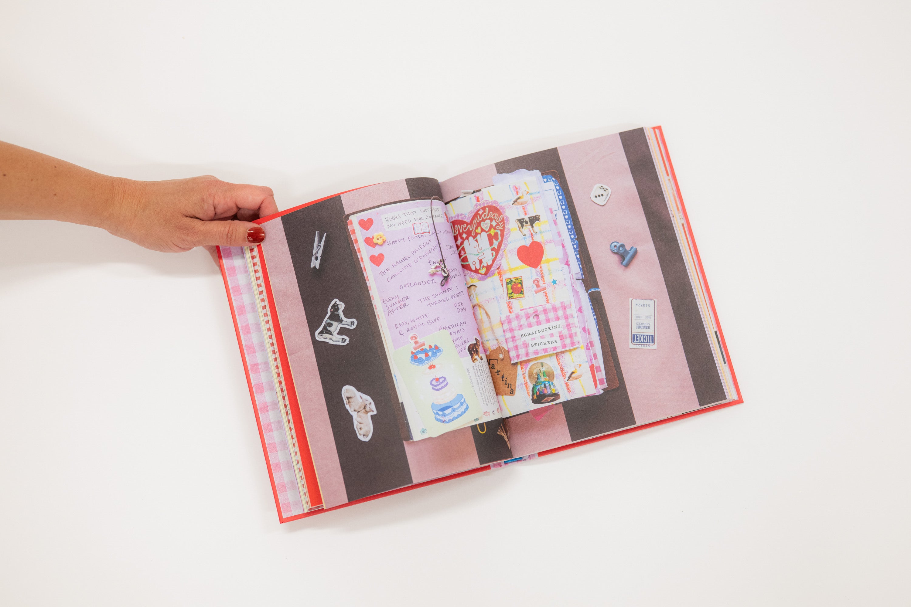 Open book with colorful pages held by a hand on a white background