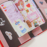 Open notebook with decorative stickers and drawings on a white background