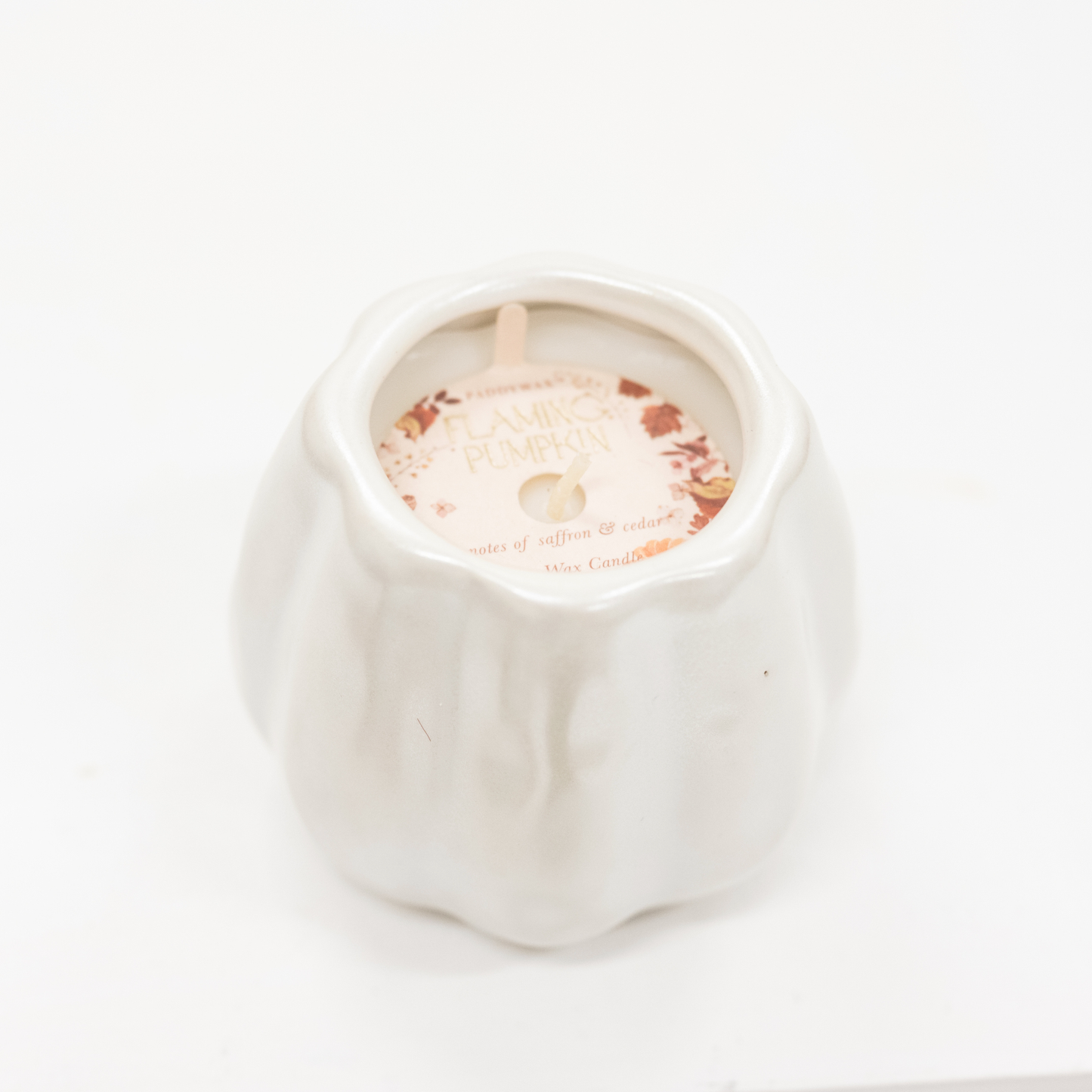 pumpkin scented candle in a metallic white ceramic vessel