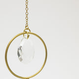 Decorative hanging item with gold frame and clear teardrop on a white background