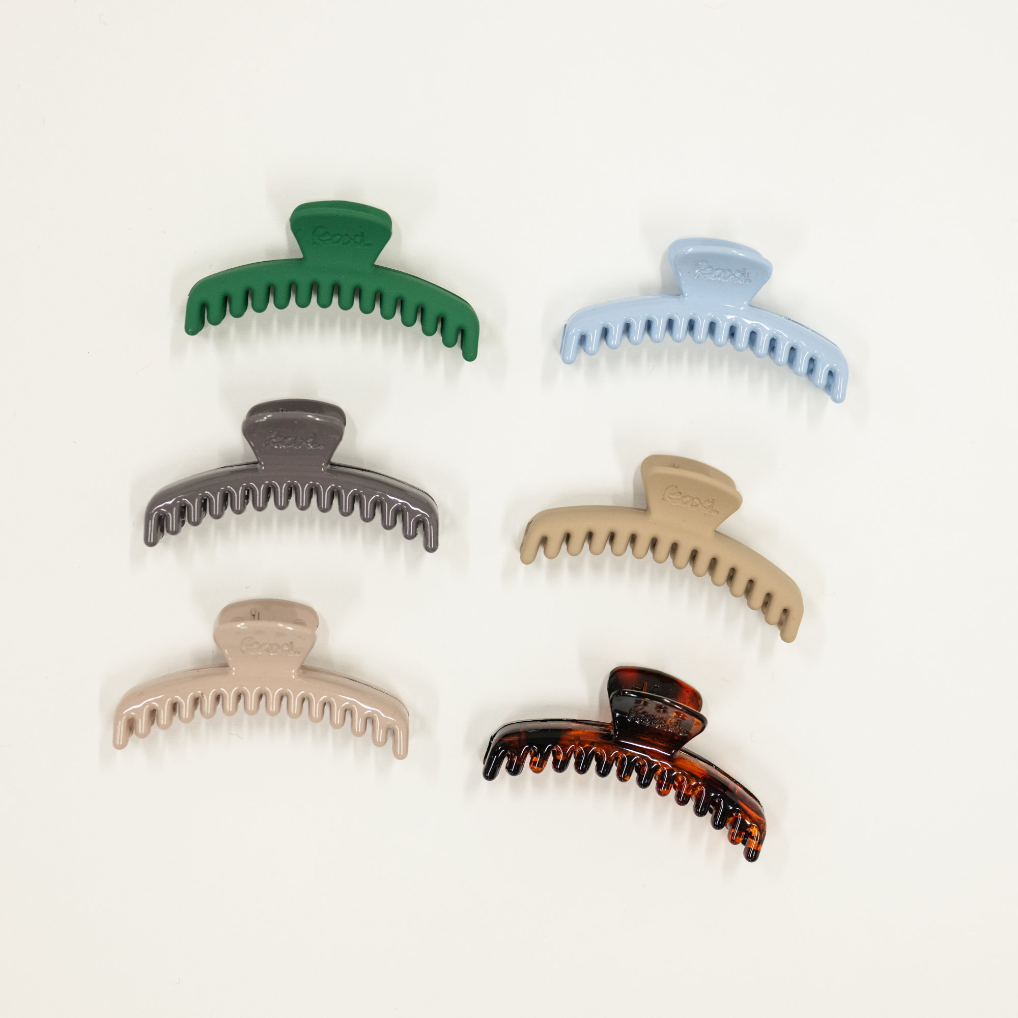 Set of six colorful mini sized hair clamps on a white background