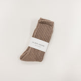 Pair of brown socks with a label on a light gray background