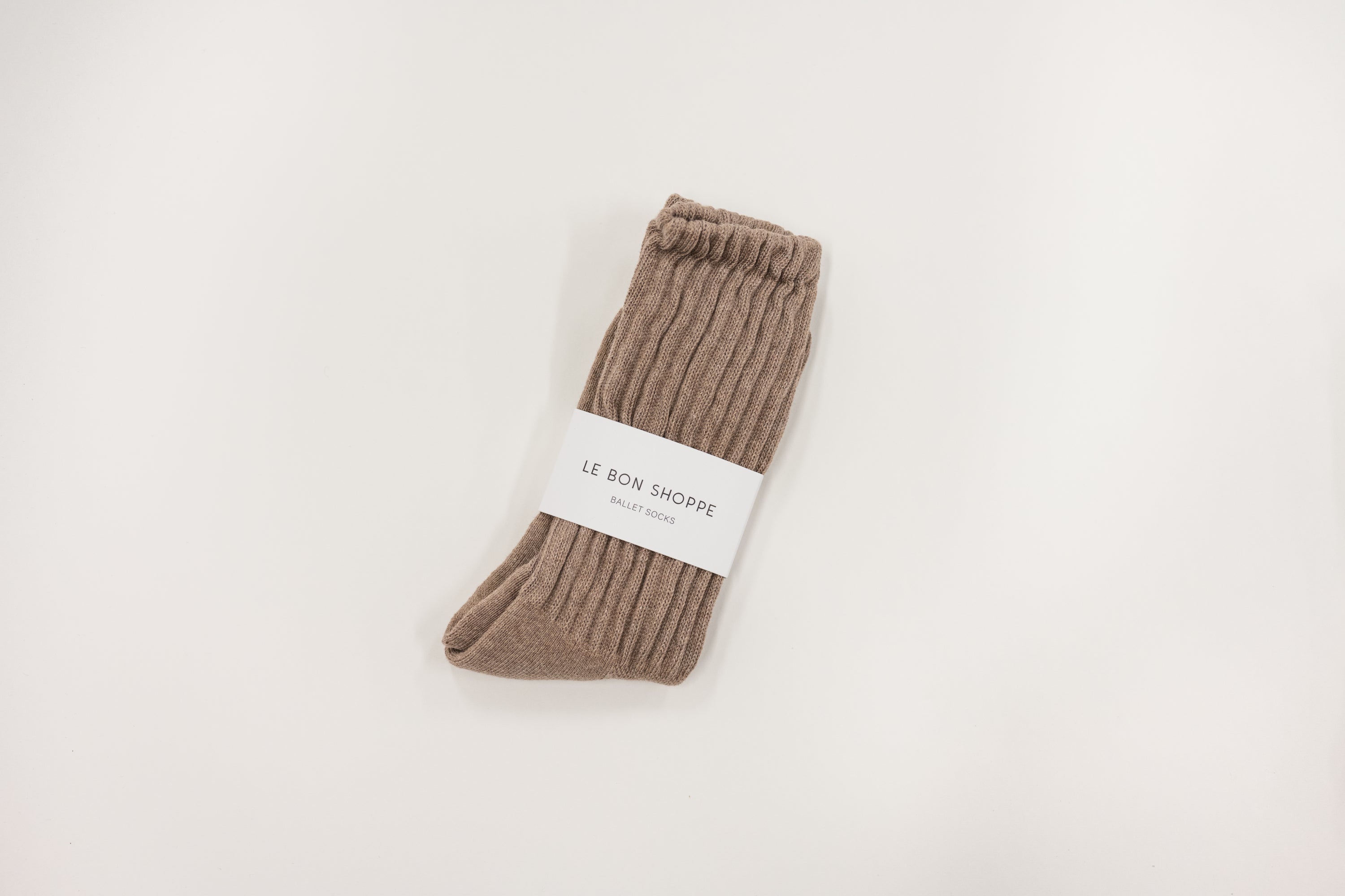 Pair of brown socks with a label on a light gray background