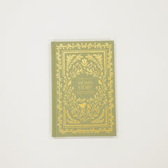 Green book with gold decorative cover on a white background