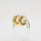 Gold hoop earrings on a clear stand against a white background