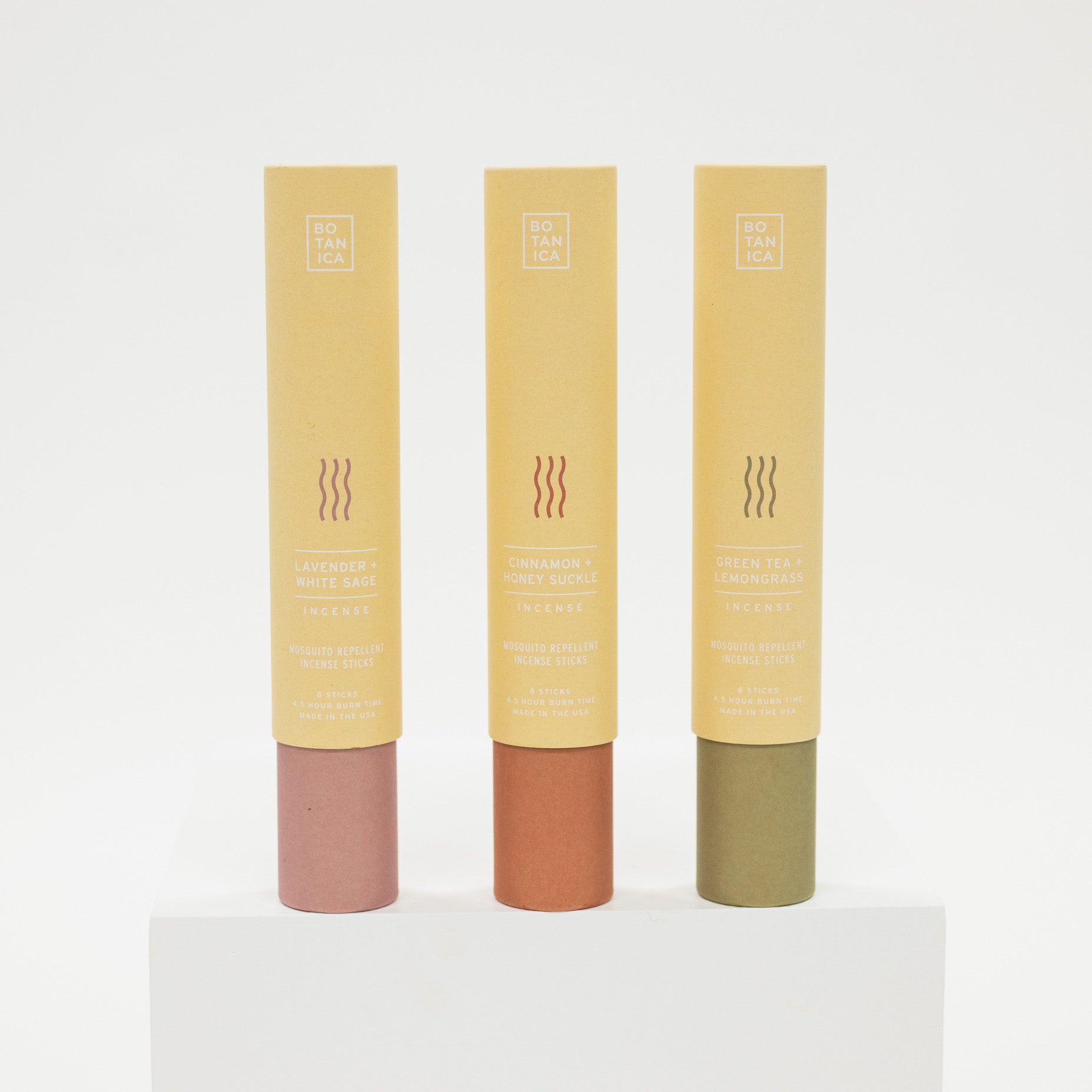 Three tubes of mosquito repellent incense with different colored caps on a white background