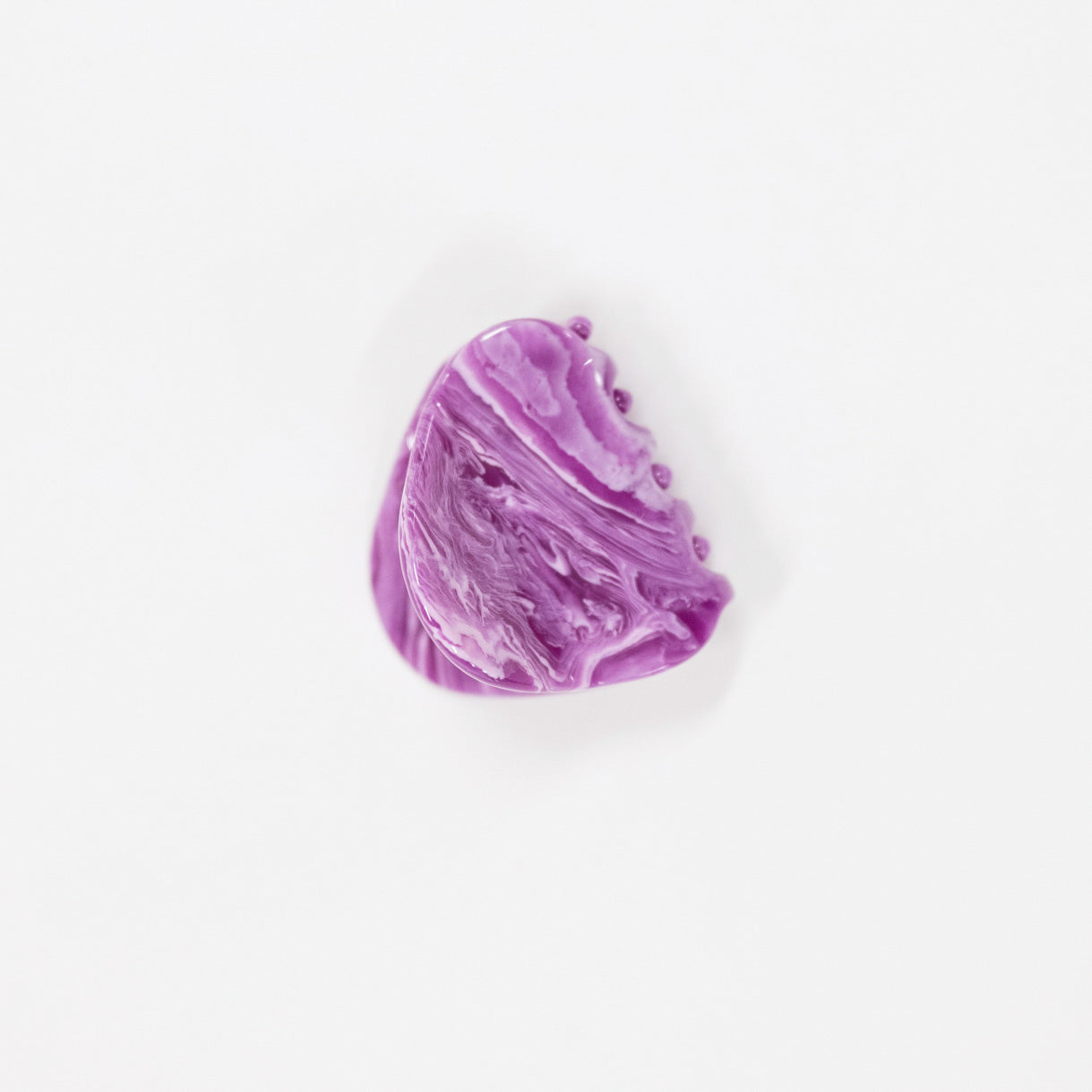 A polished purple stone hair clip with natural marbled swirls, displayed on a clean white background.