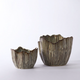 A mushroom top inspired flower pot made from ceramic with a brown glazing.