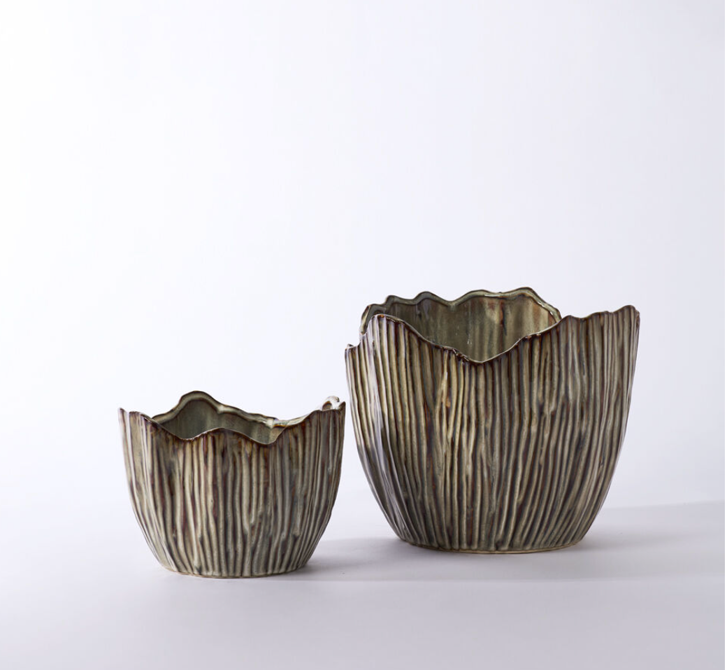 A mushroom top inspired flower pot made from ceramic with a brown glazing.